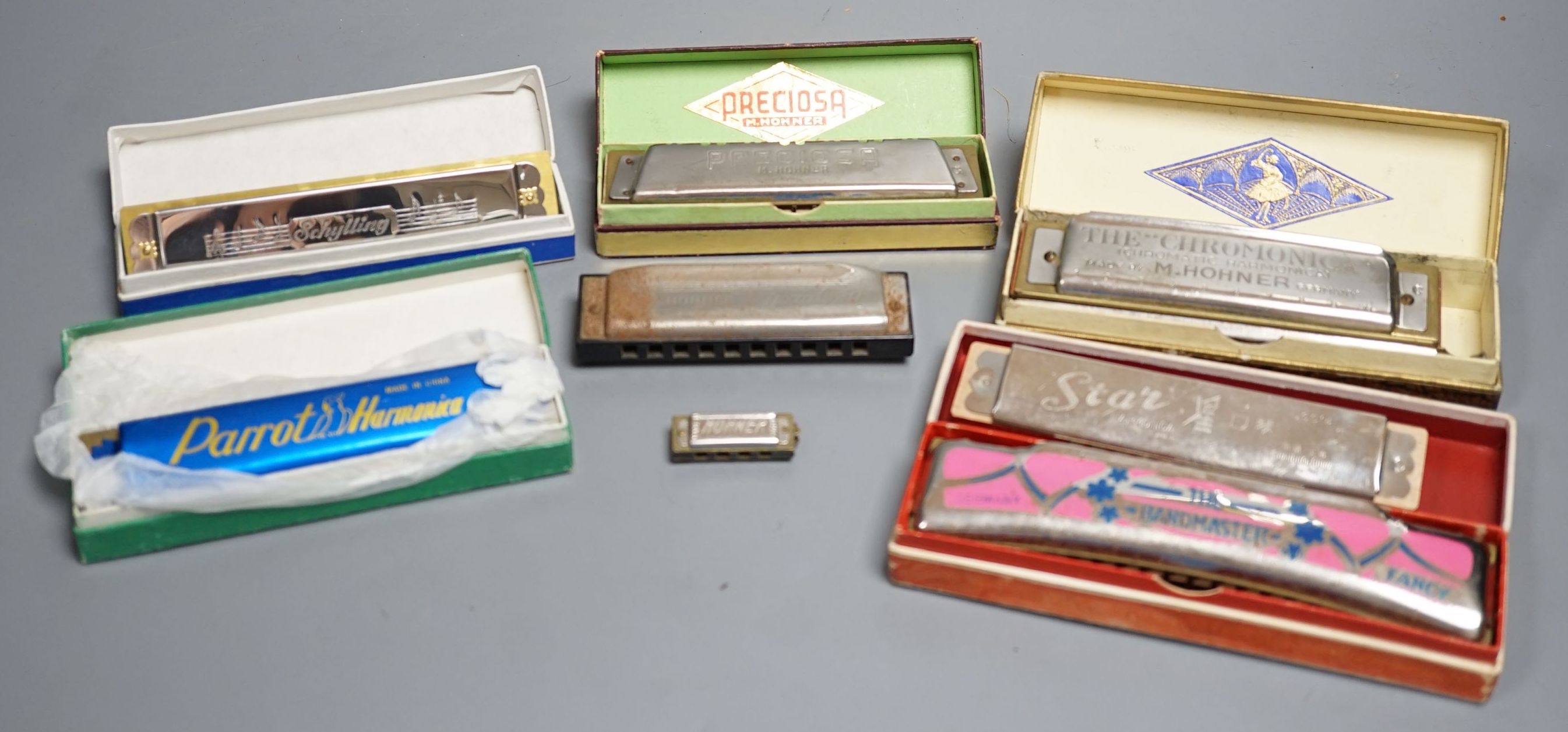 Eight various harmonicas, some with boxes
